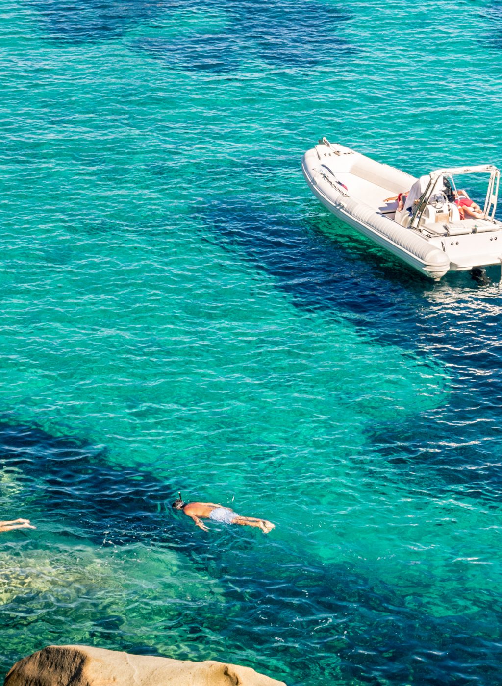 Modern luxury dinghy on turquoise sea with clear blue water in tropical island - People snorkeling in exclusive exotic travel destination - Vacation concept with friends having fun together
